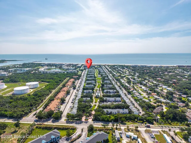 an aerial view of residential houses with yard and ocean view