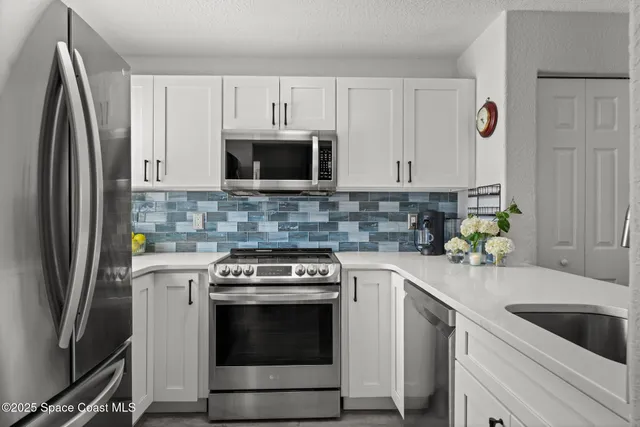 a kitchen with cabinets stainless steel appliances and a sink