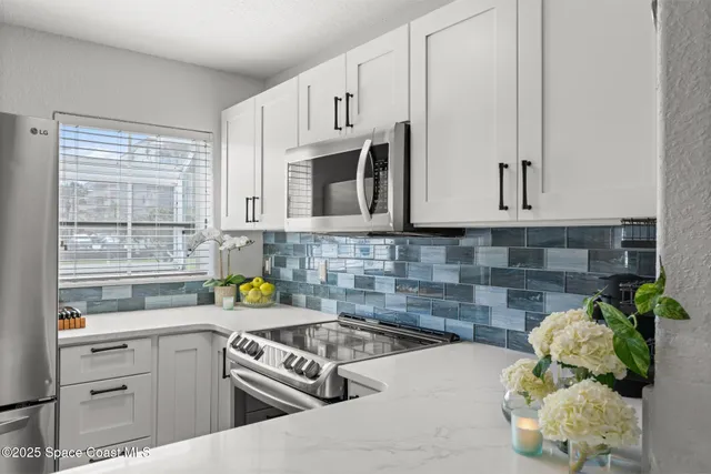 a kitchen with stainless steel appliances white cabinets and a stove top oven