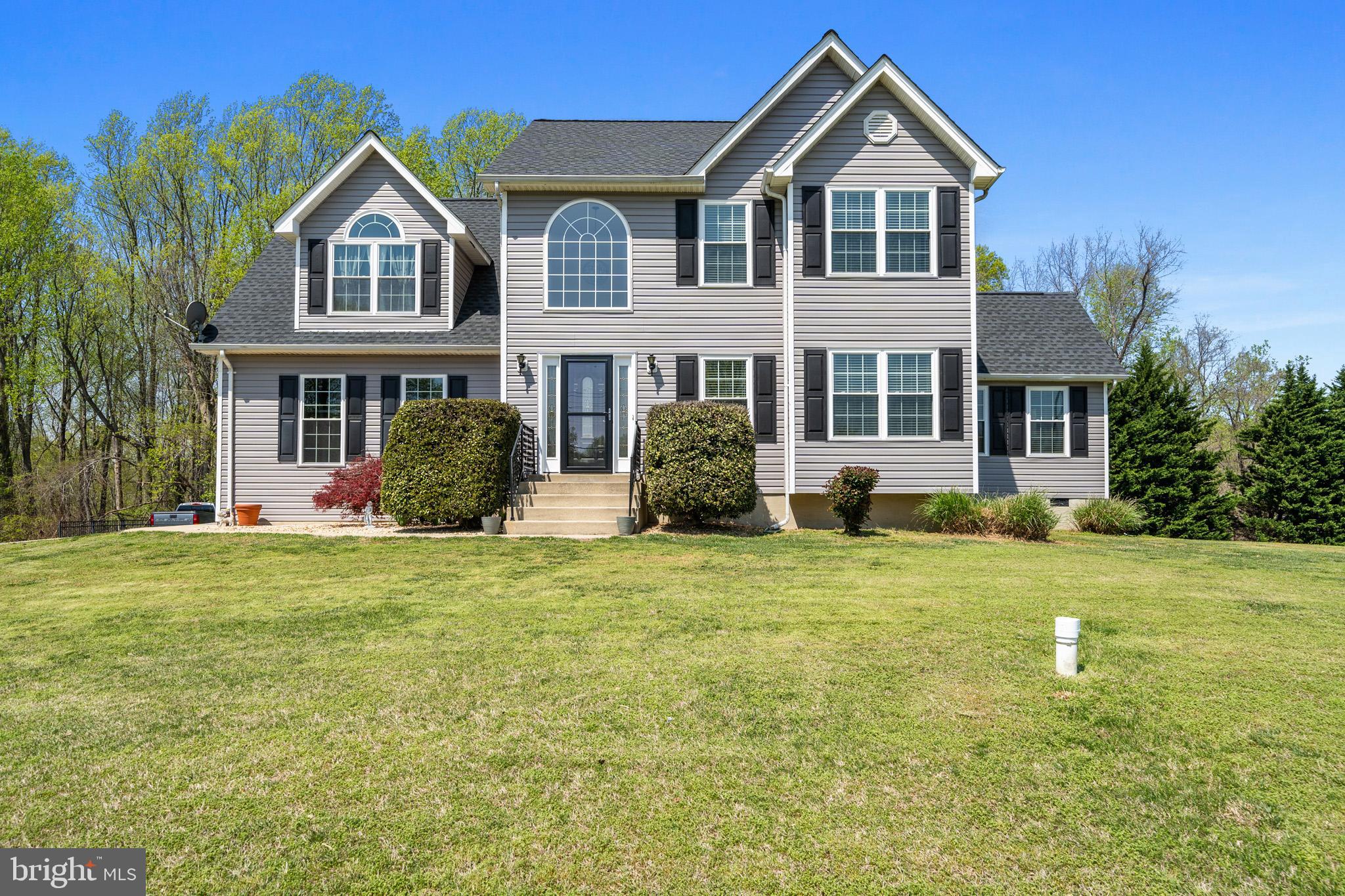 1230 Plum Point Road Huntingtown, MD 20639 - Photo 1 of 79 a front view of a house with a yard and trees