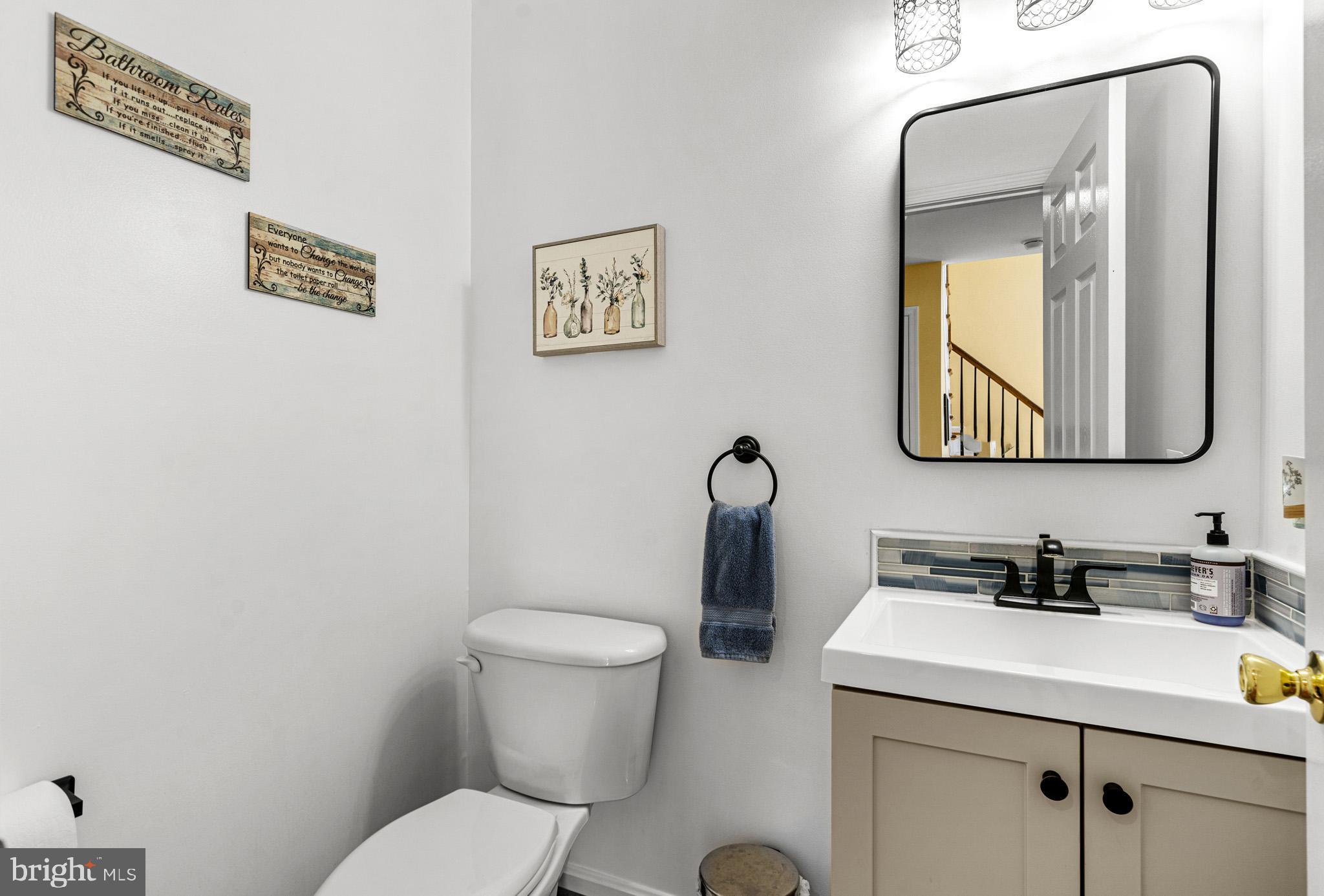 1230 Plum Point Road Huntingtown, MD 20639 - Photo 19 of 79 a bathroom with a toilet sink vanity and mirror