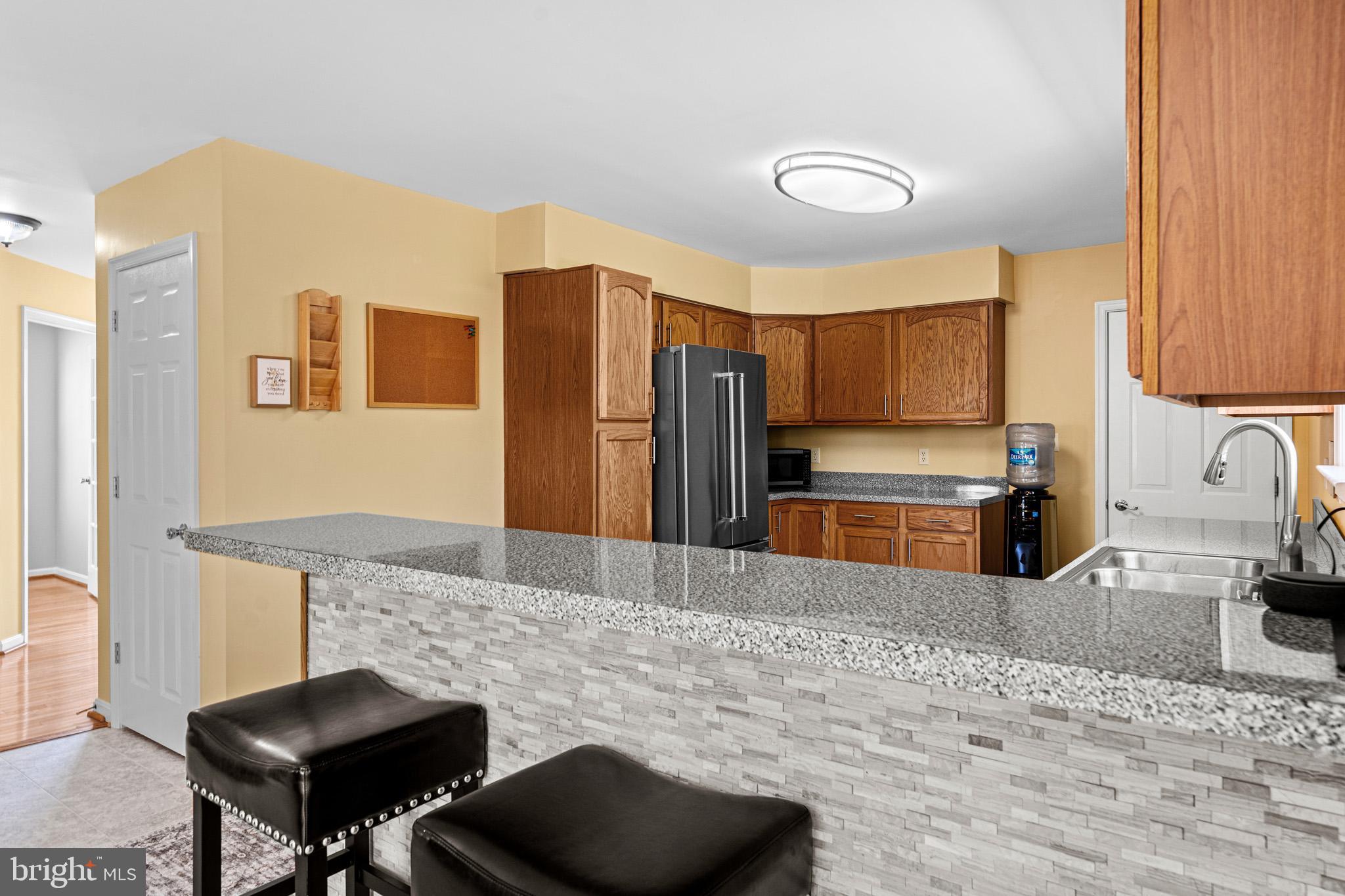 1230 Plum Point Road Huntingtown, MD 20639 - Photo 21 of 79 a kitchen with stainless steel appliances granite countertop a sink refrigerator and cabinets