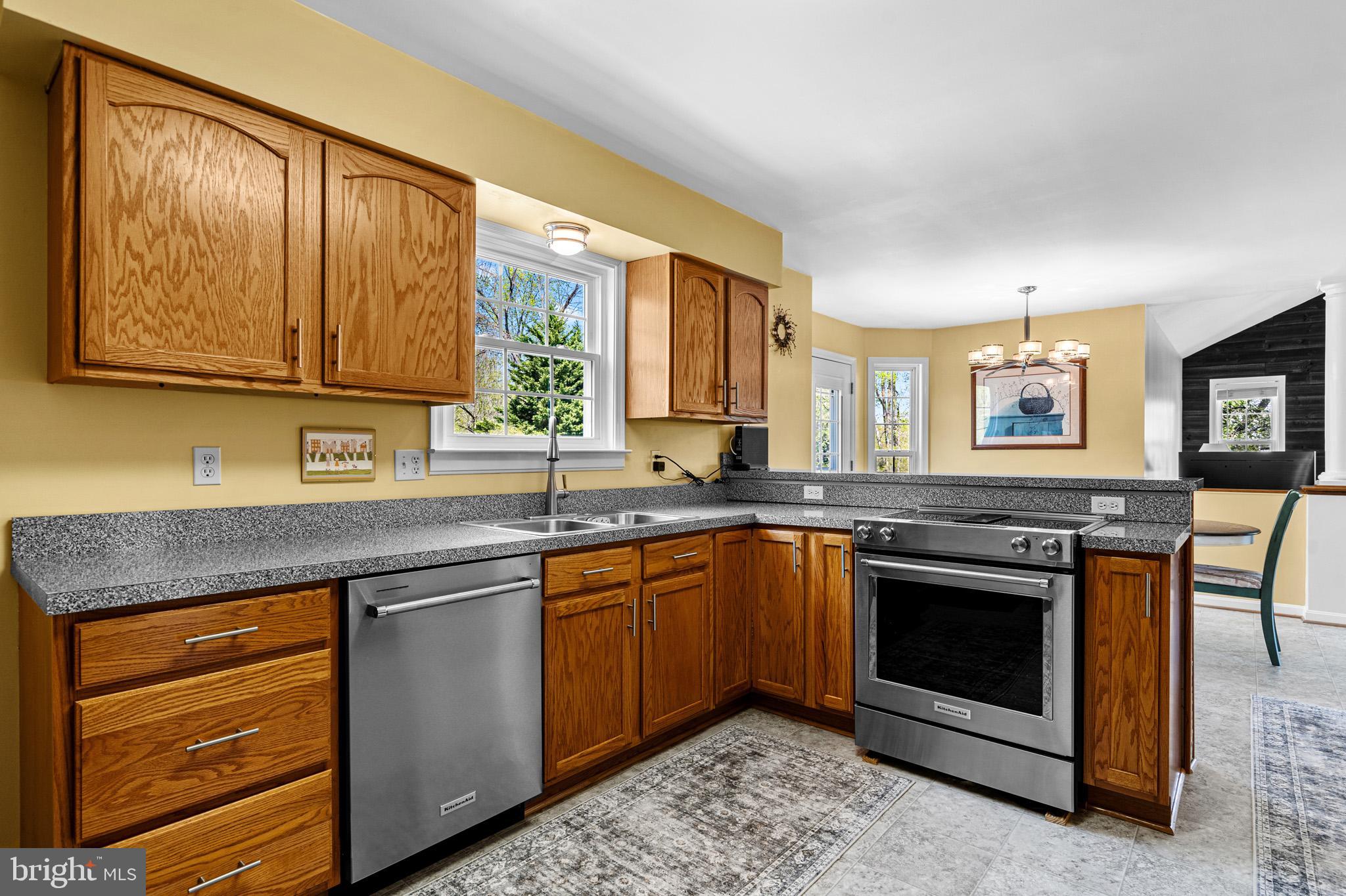 1230 Plum Point Road Huntingtown, MD 20639 - Photo 24 of 79 a kitchen with stainless steel appliances granite countertop a stove a sink and a microwave