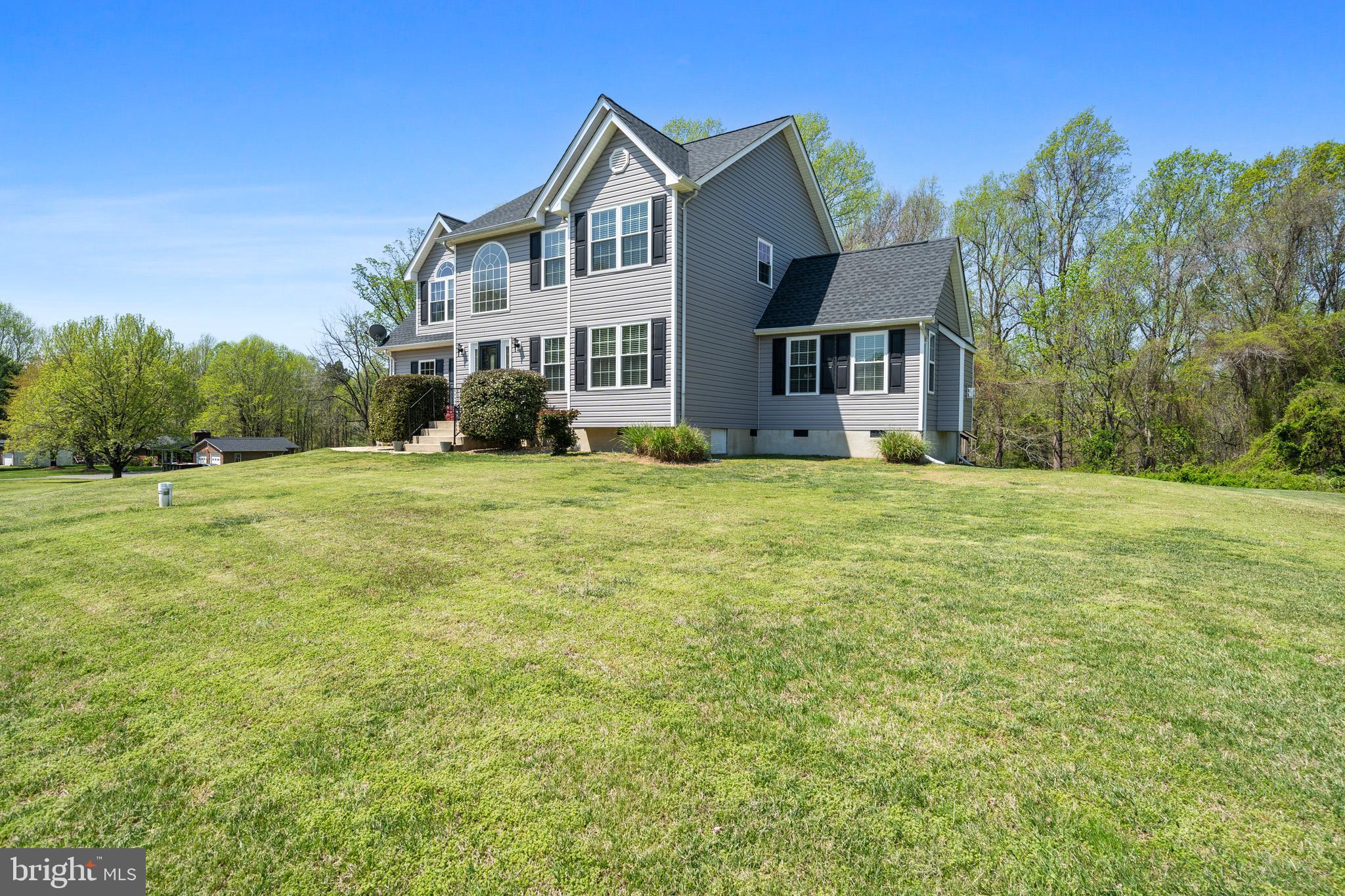 1230 Plum Point Road Huntingtown, MD 20639 - Photo 4 of 79 a view of a big house with a big yard and large trees