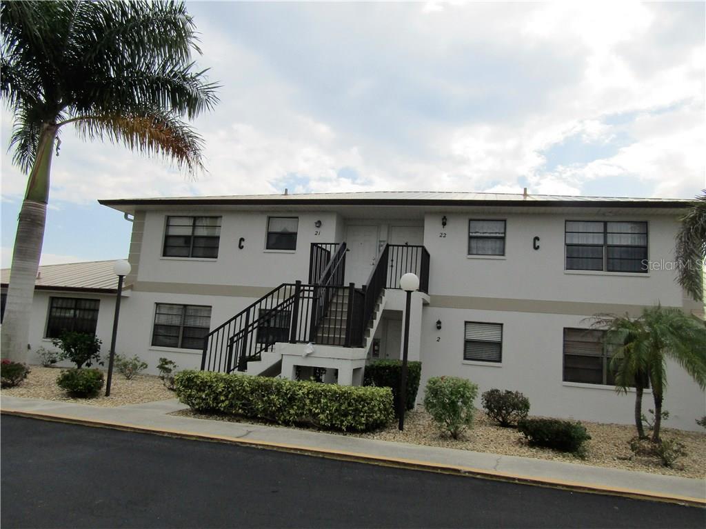 26485 Rampart Boulevard, Unit C21 Punta Gorda, FL 33983 - Photo 1 of 1 a front view of a house with a yard and garage