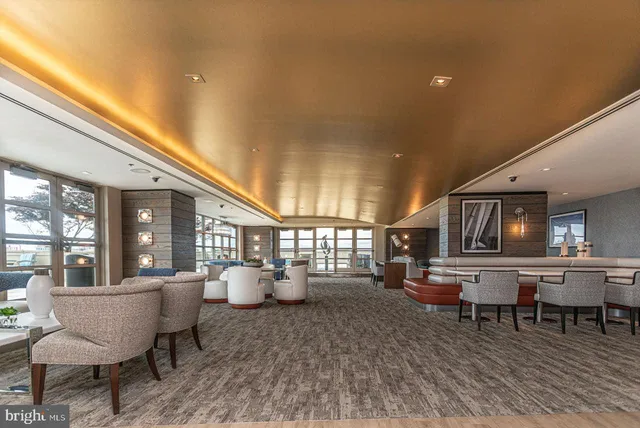 a living room with furniture a table and kitchen view