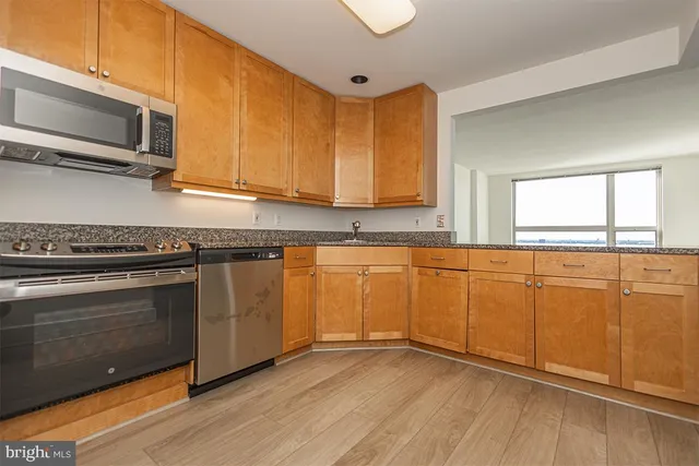 a kitchen with granite countertop cabinets stainless steel appliances and a sink