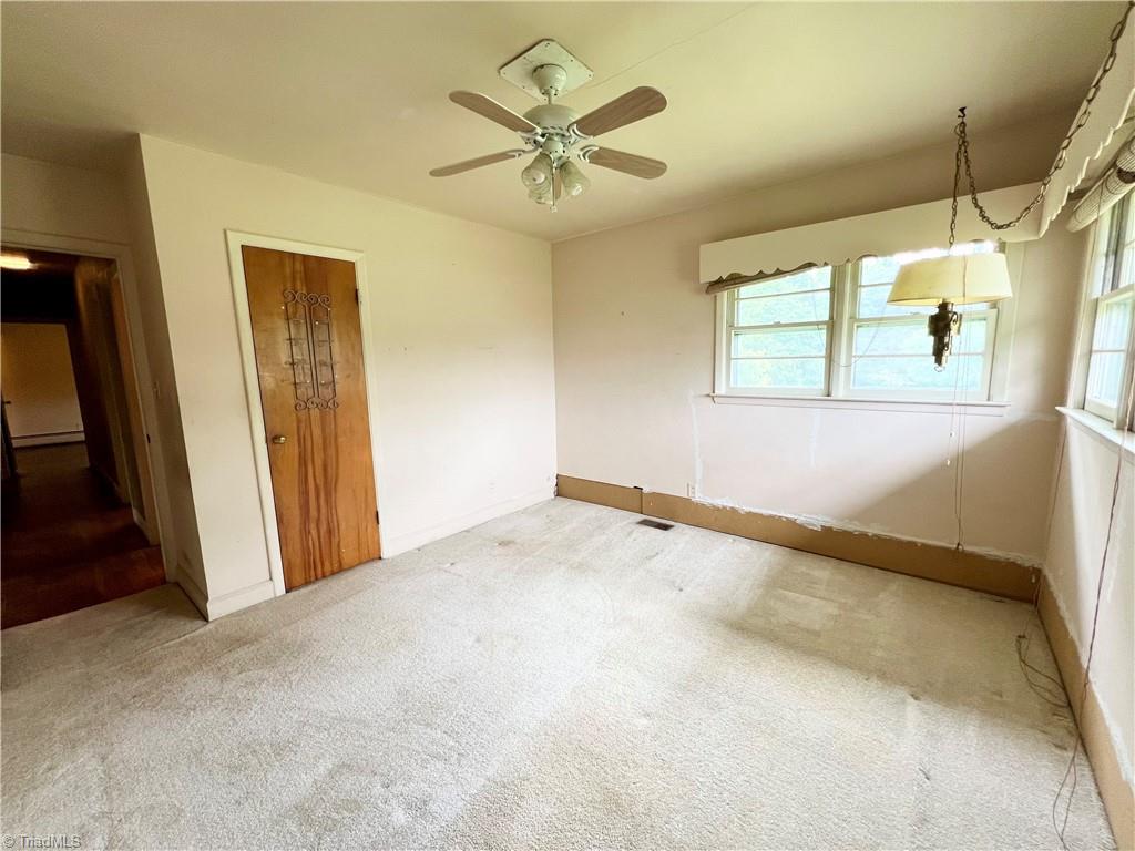 3684 Oak Ridge Road Summerfield, NC 27358 - Photo 16 of 42 2nd bedroom has carpet. Please note bottom of wall where old radiator style heat registers were removed and patched. (work was not completed)