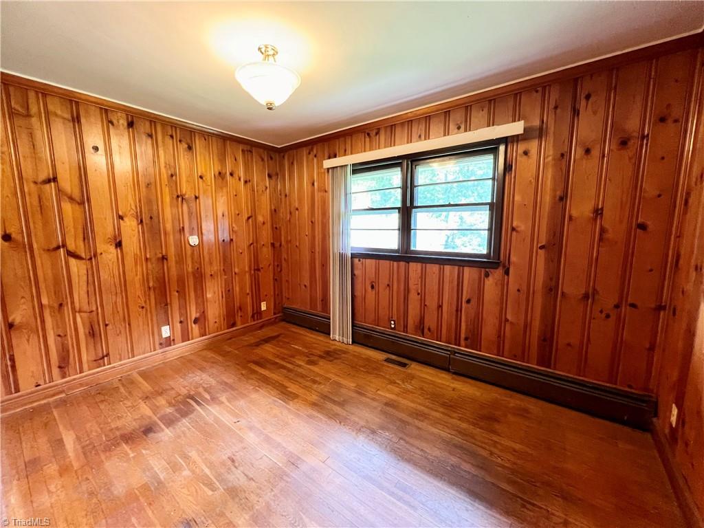 3684 Oak Ridge Road Summerfield, NC 27358 - Photo 19 of 42 Bedroom 3 with wood paneling. Closet for this bedroom is located in the hallway
