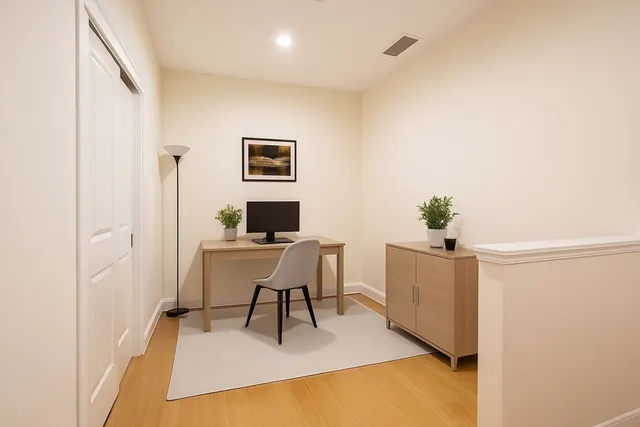 a view of a workspace with furniture and wooden floor