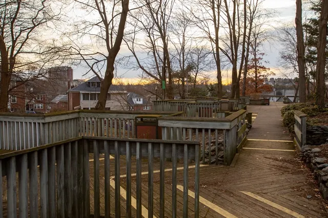 a view of residential houses with trees and wooden fence