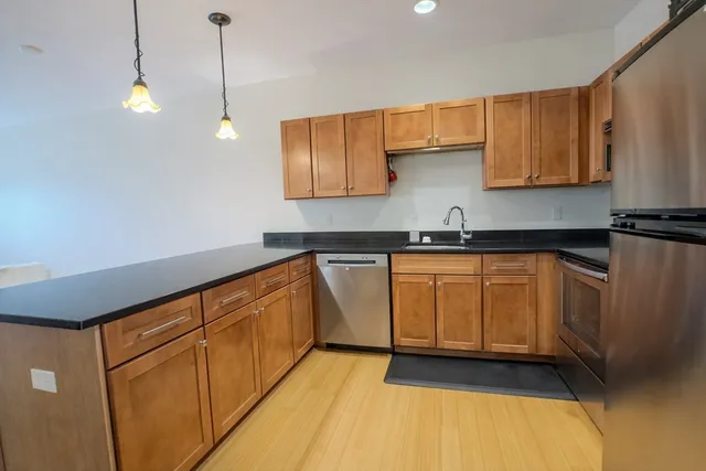 a kitchen with granite countertop a sink a stove and cabinets