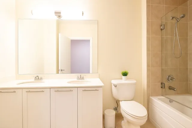 a bathroom with a sink a toilet a mirror and shower