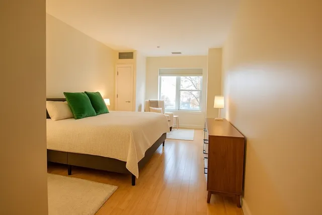 a bedroom with a bed and wooden floor