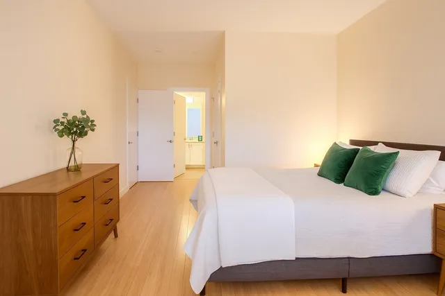 a bedroom with a bed and a potted plant