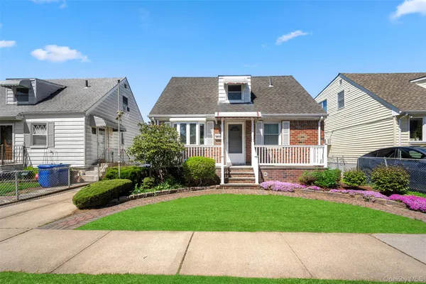 a front view of a house with a garden and plants