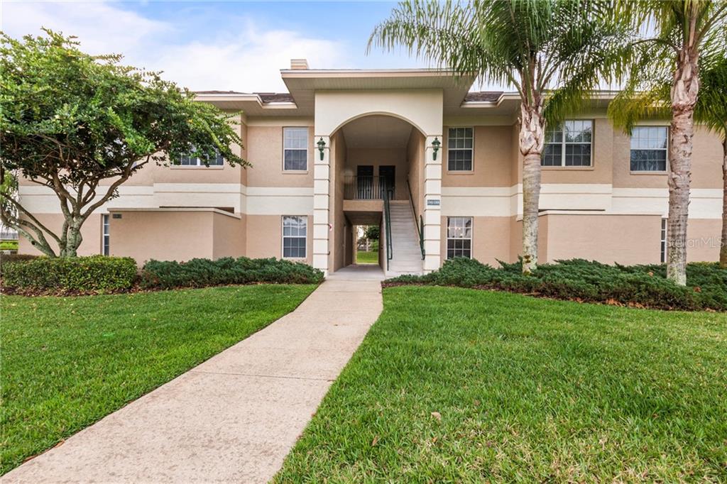 a front view of a house with garden and trees