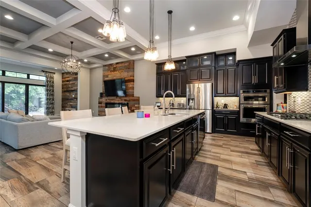 a kitchen with stainless steel appliances kitchen island granite countertop a sink a stove and a refrigerator