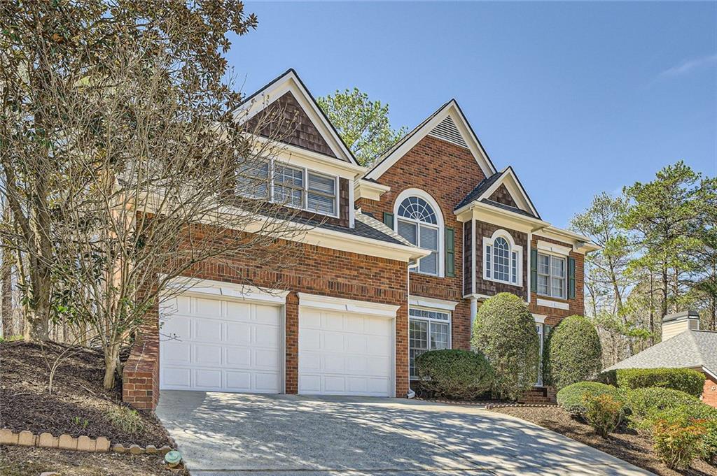 a view of a white house next to a road and yard
