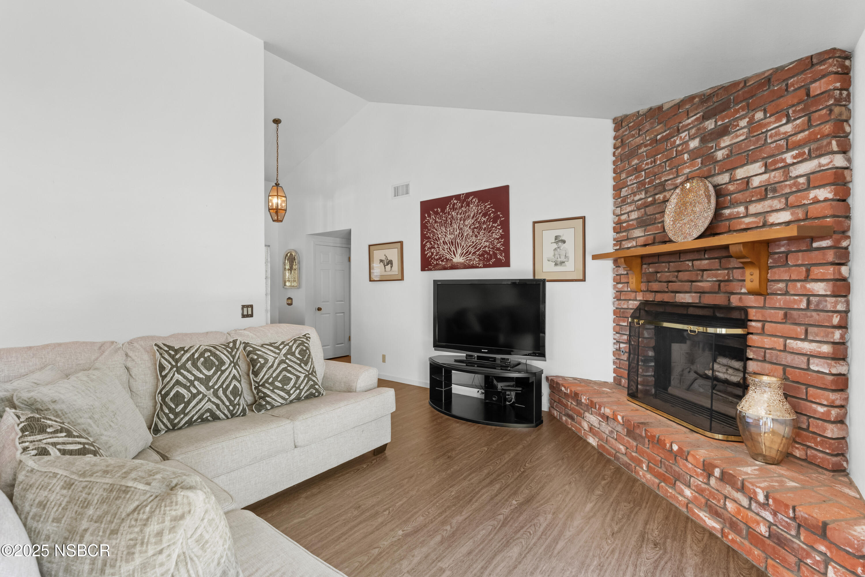 181 Eucalyptus Road Nipomo, CA 93444 - Photo 12 of 36 a living room with furniture a flat screen tv and a fireplace