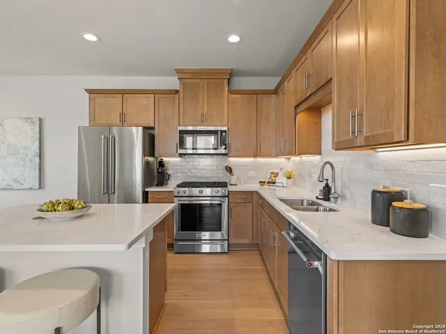 a kitchen with a refrigerator a stove a sink and a microwave