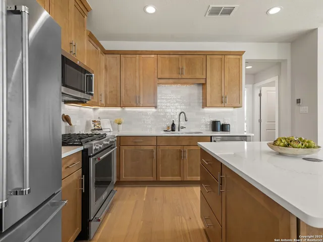 a kitchen with stainless steel appliances granite countertop a sink stove and refrigerator