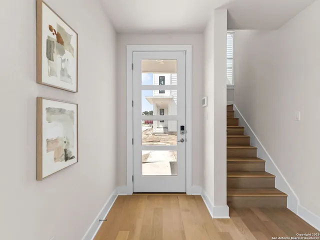 a view of a hallway with entryway and wooden floor
