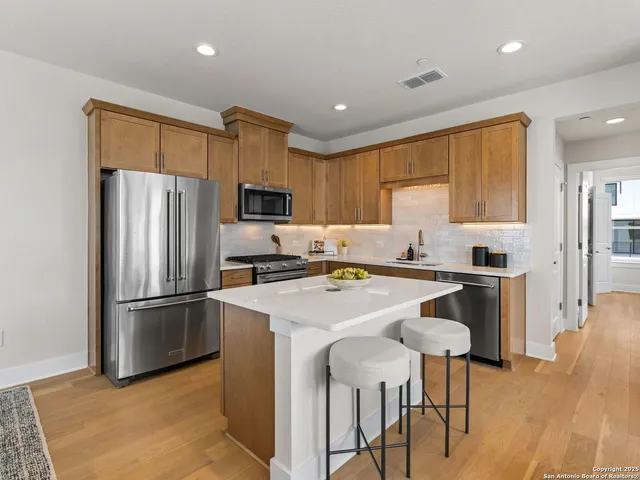 a kitchen with granite countertop a refrigerator stove microwave and cabinets