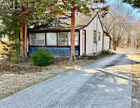 a view of a house with backyard and trees