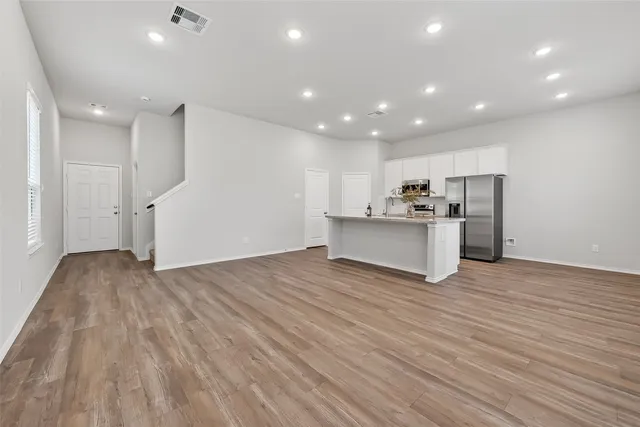 a view of empty room with wooden floor