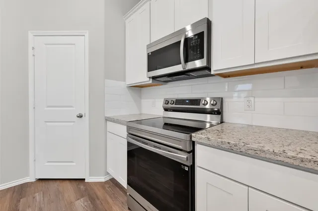 a kitchen with stainless steel appliances granite countertop a stove microwave and sink