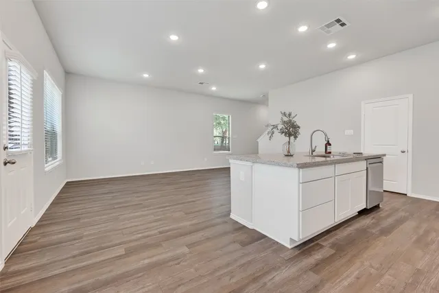 a kitchen with a sink cabinets and wooden floor