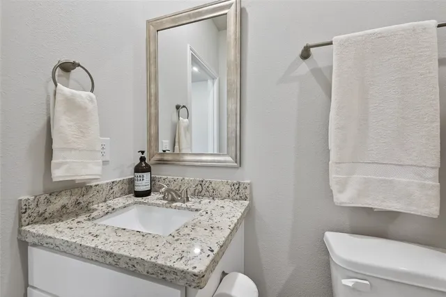 a bathroom with a granite countertop sink and a mirror