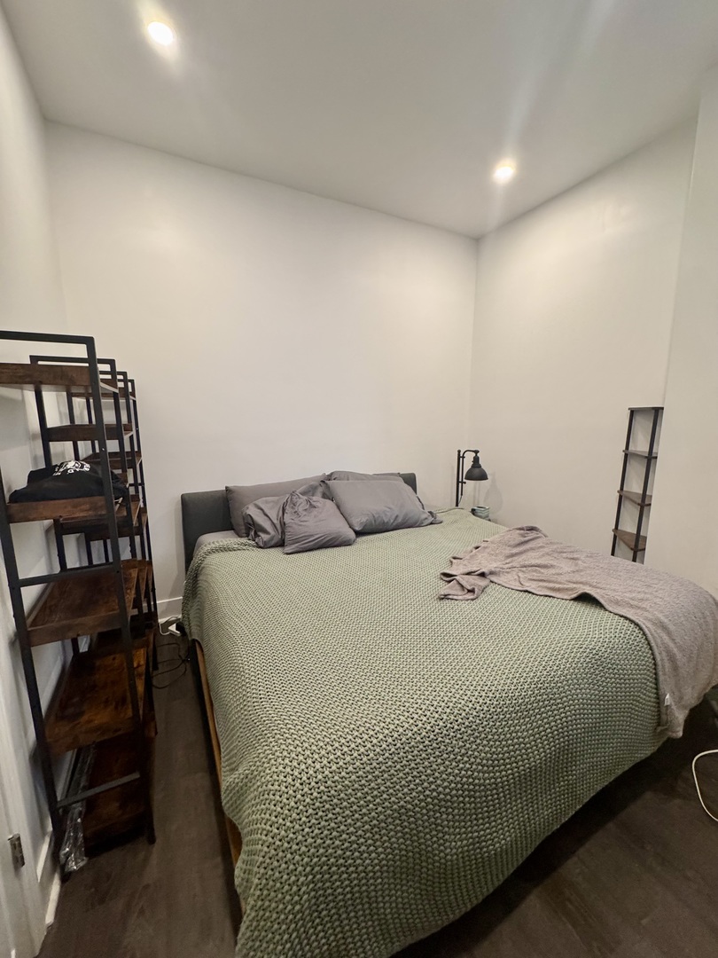 948 West Addison Street, Unit 3 Chicago, IL 60613 - Photo 6 of 11 a bedroom with a bed a table and chair
