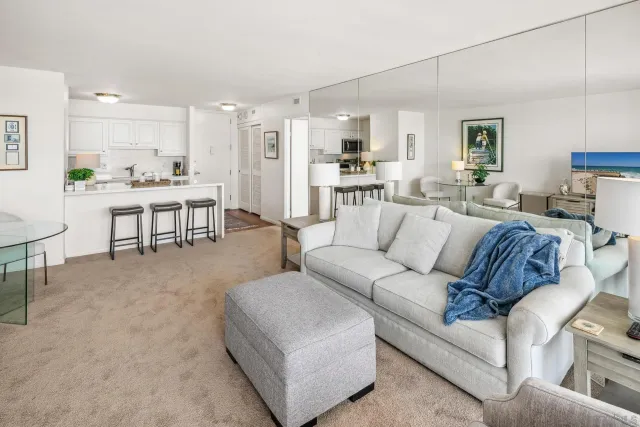 a living room with furniture and view of kitchen