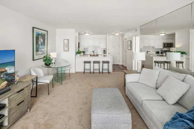 a living room with furniture and view of kitchen