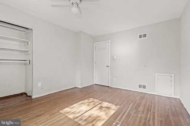 a view of a room with wooden floor and white walls