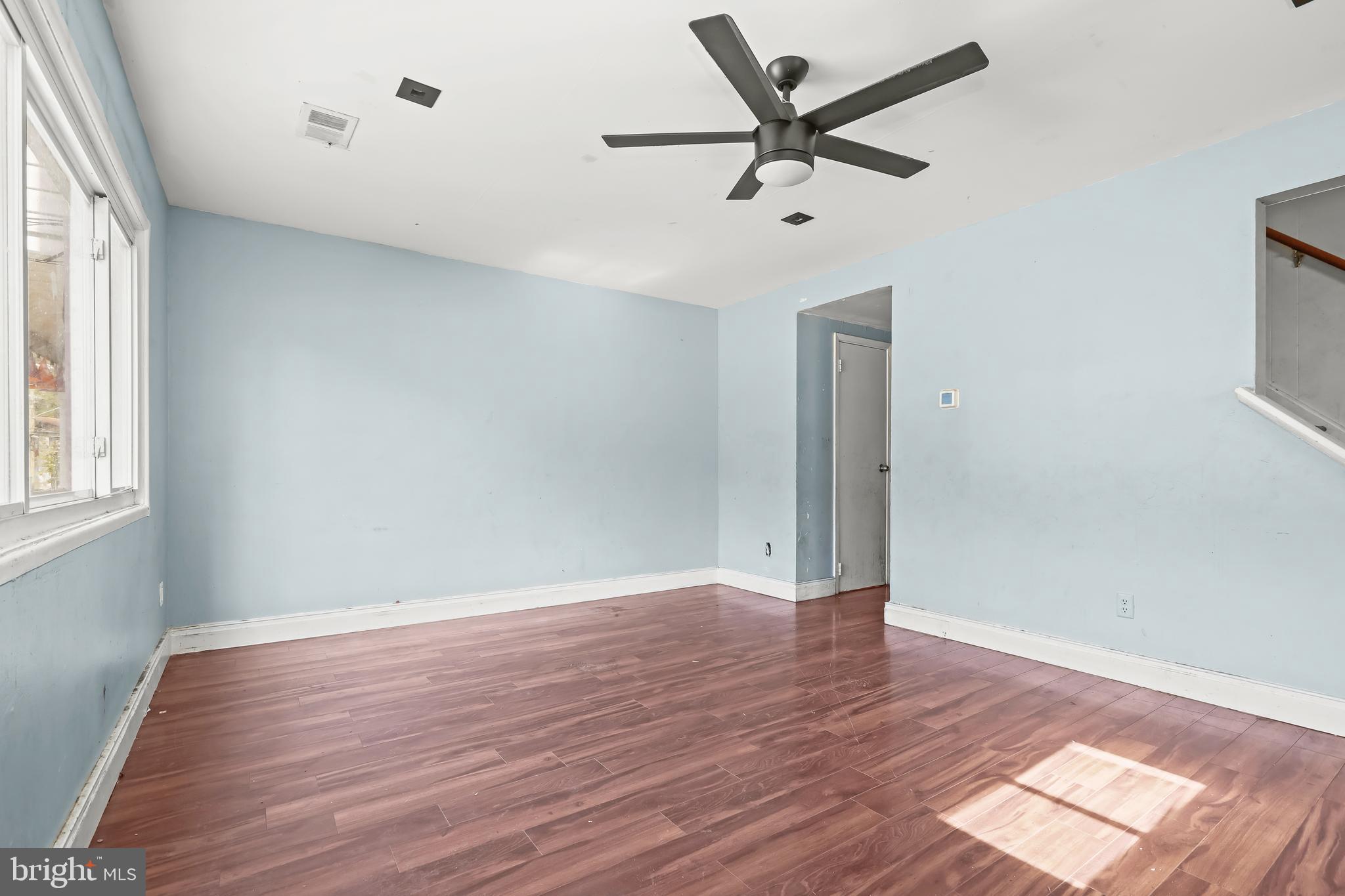 2217 Columbia Place Landover, MD 20785 - Photo 2 of 34 an empty room with wooden floor fan and windows