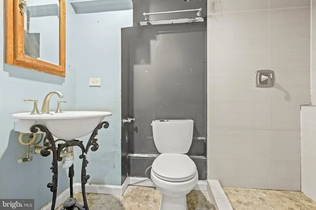 a bathroom with a toilet sink and mirror
