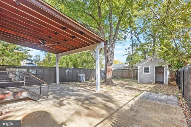 a view of a house with a small yard and a large tree