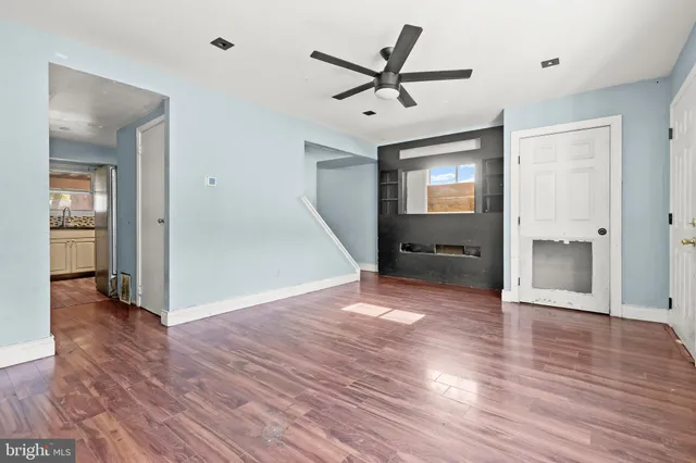 a view of empty room with wooden floor and window