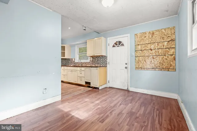 an empty room with wooden floor and windows