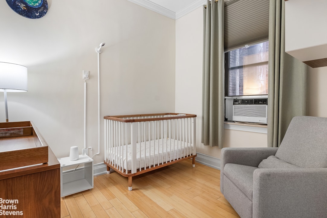 229 West 97th Street, Unit 6E Manhattan, NY 10025 - Photo 5 of 21 a living room with a baby crib furniture and a window