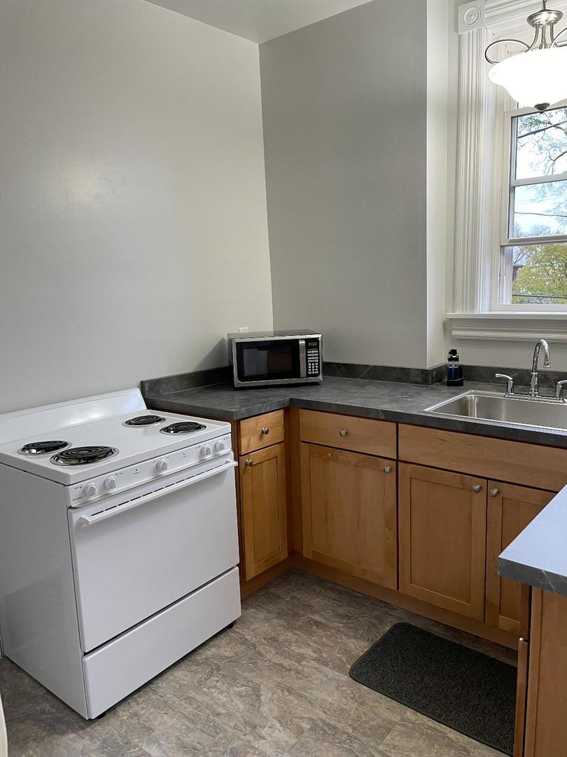 718 1/2 Columbus Street, Unit 2 Ottawa, IL 61350 - Photo 2 of 13 a kitchen with granite countertop white cabinets sink and stove