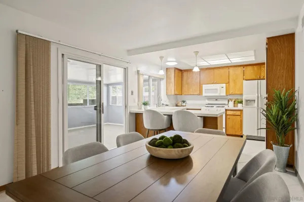 a large white kitchen with a large window and stainless steel appliances