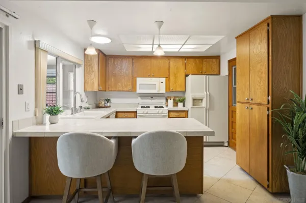 a kitchen with refrigerator cabinets table and chairs