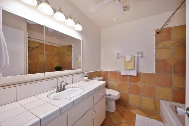 a bathroom with a double vanity sink toilet mirror and shower