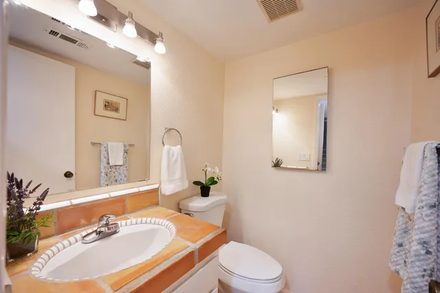 a bathroom with a sink a toilet a mirror and vanity