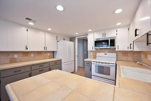 a kitchen with a sink a stove and oven