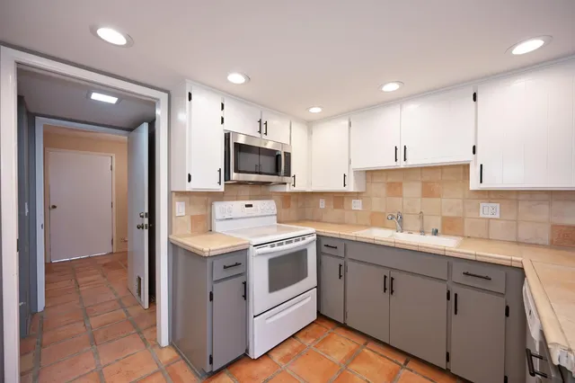 a kitchen with a sink stove and cabinets